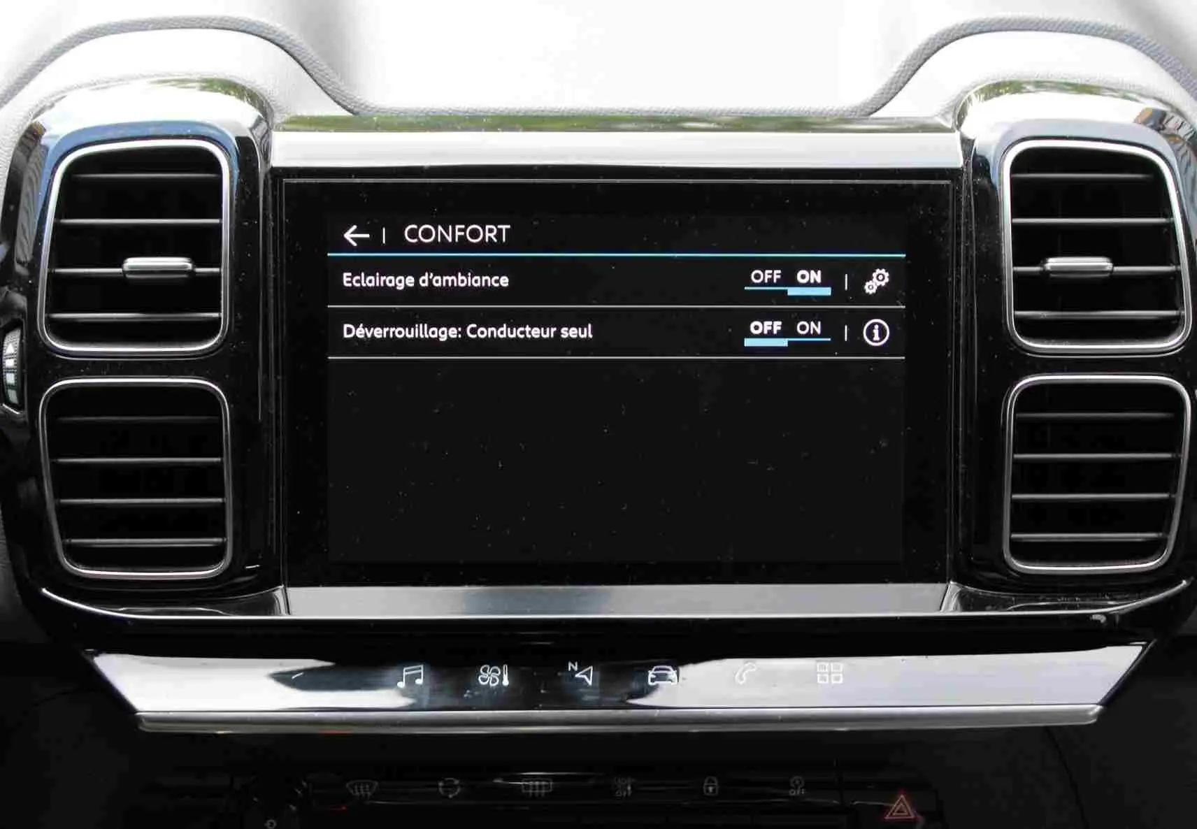 Écran tactile central du tableau de bord du Citroën C5 Aircross blanc, avec commandes d’ambiance et déverrouillage.