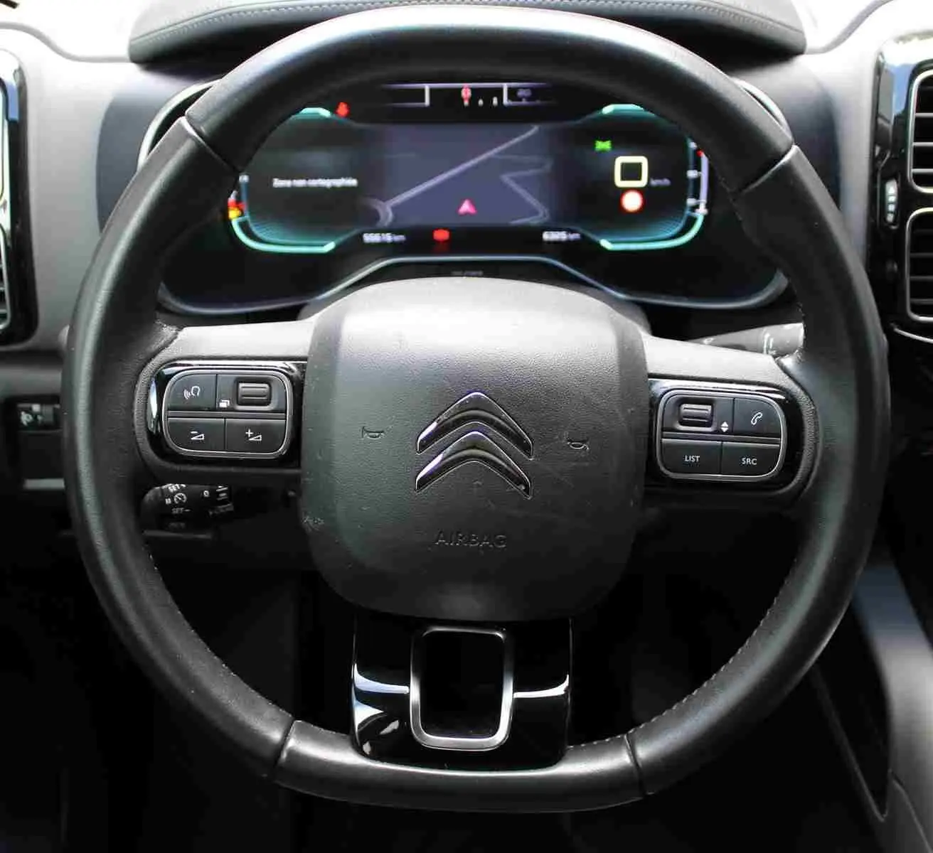 Vue rapprochée du volant noir du Citroën C5 Aircross 2020 avec commandes intégrées et tableau de bord numérique.