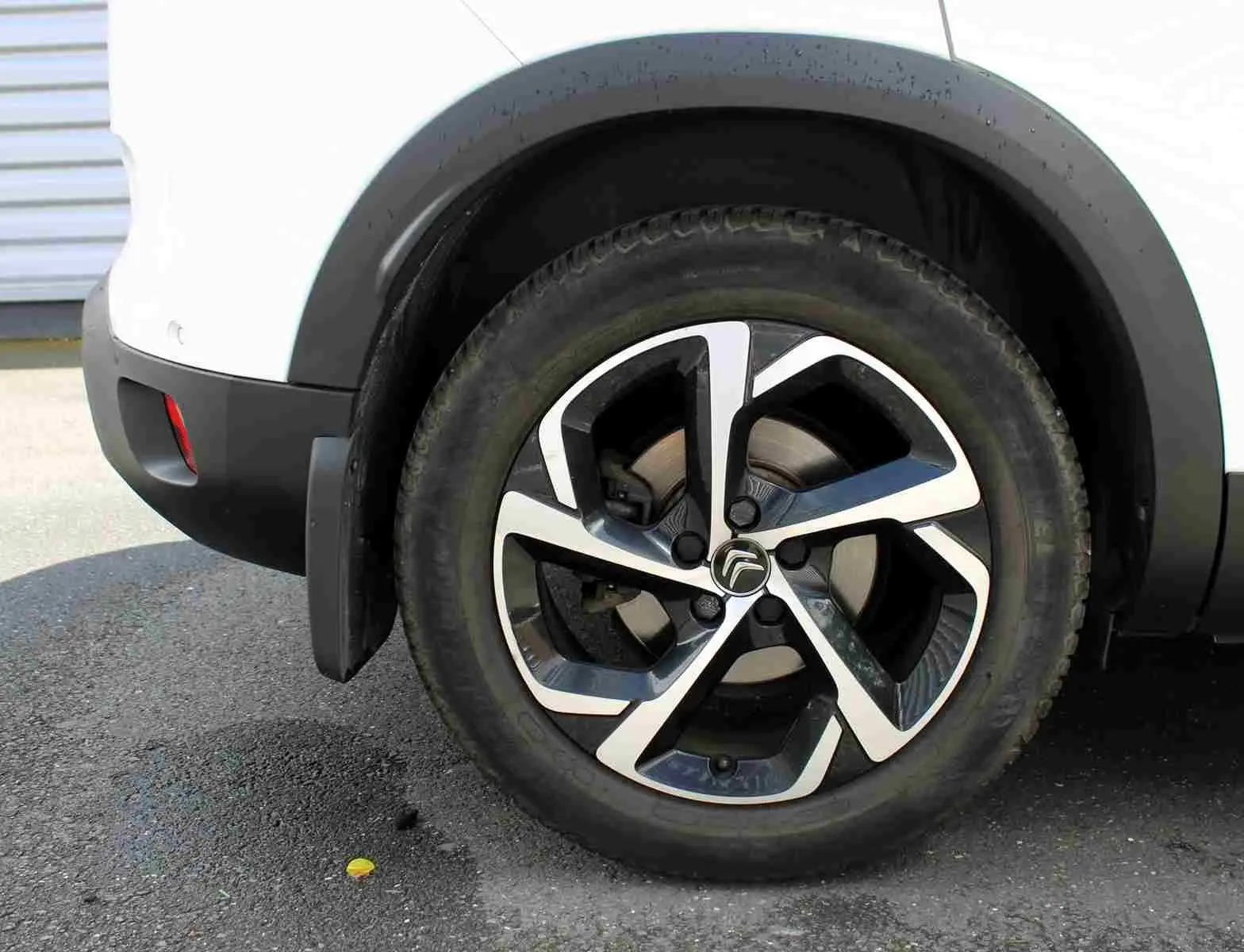 Gros plan sur la roue arrière droite du Citroën C5 Aircross blanc, avec jante alliage au design moderne bicolore.