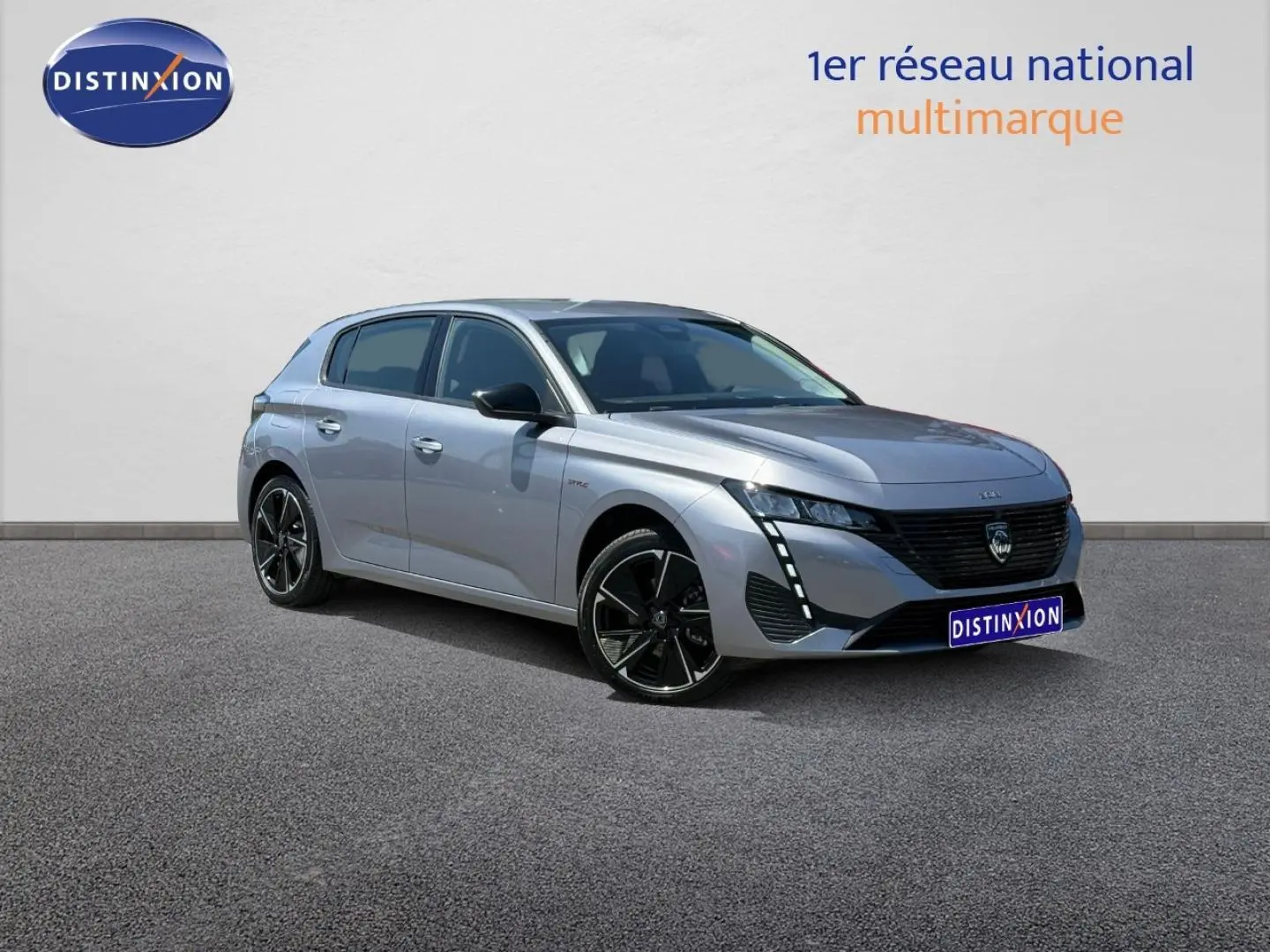 Peugeot e-308 gris Artense vue 3/4 avant droit, avec jantes alliage noires et feux LED verticaux distinctifs.