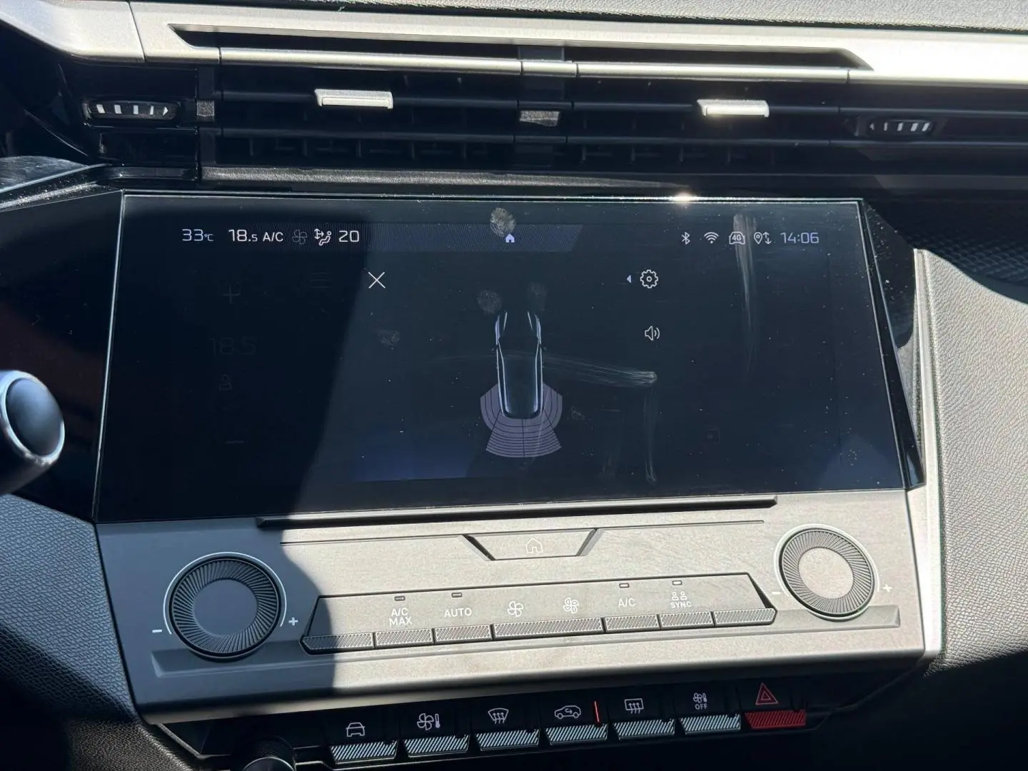 Vue rapprochée de l’écran tactile central et des commandes de climatisation du tableau de bord de la Peugeot 308 e-308 gris Artense.