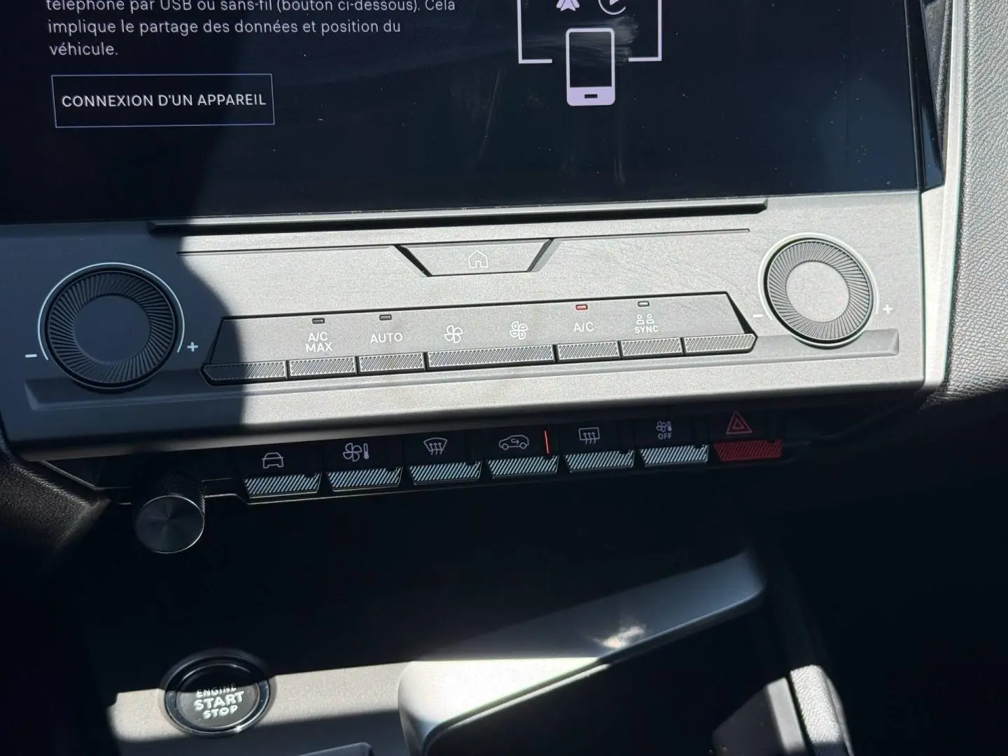 Vue rapprochée de la console centrale de la Peugeot e-308 gris Artense, avec écran tactile et commandes climatisation.