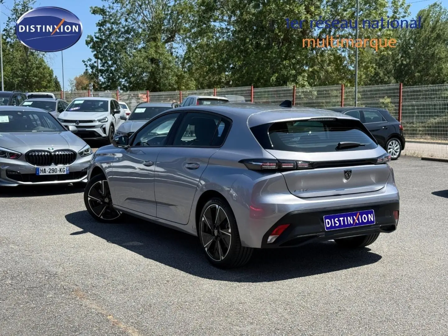 Vue 3/4 arrière droite de la Peugeot e-308 gris Artense avec feux arrière LED et jantes alliage noires.