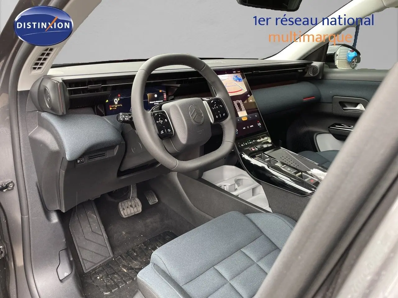 Vue intérieure côté conducteur du Citroën C5 Aircross Hybrid 2026, avec tableau de bord moderne et sellerie tissu gris.