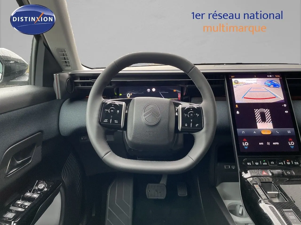 Intérieur de la Citroën C5 Aircross Hybrid 2026, vue du poste de conduite avec volant multifonction et écran tactile affichant la caméra de recul.