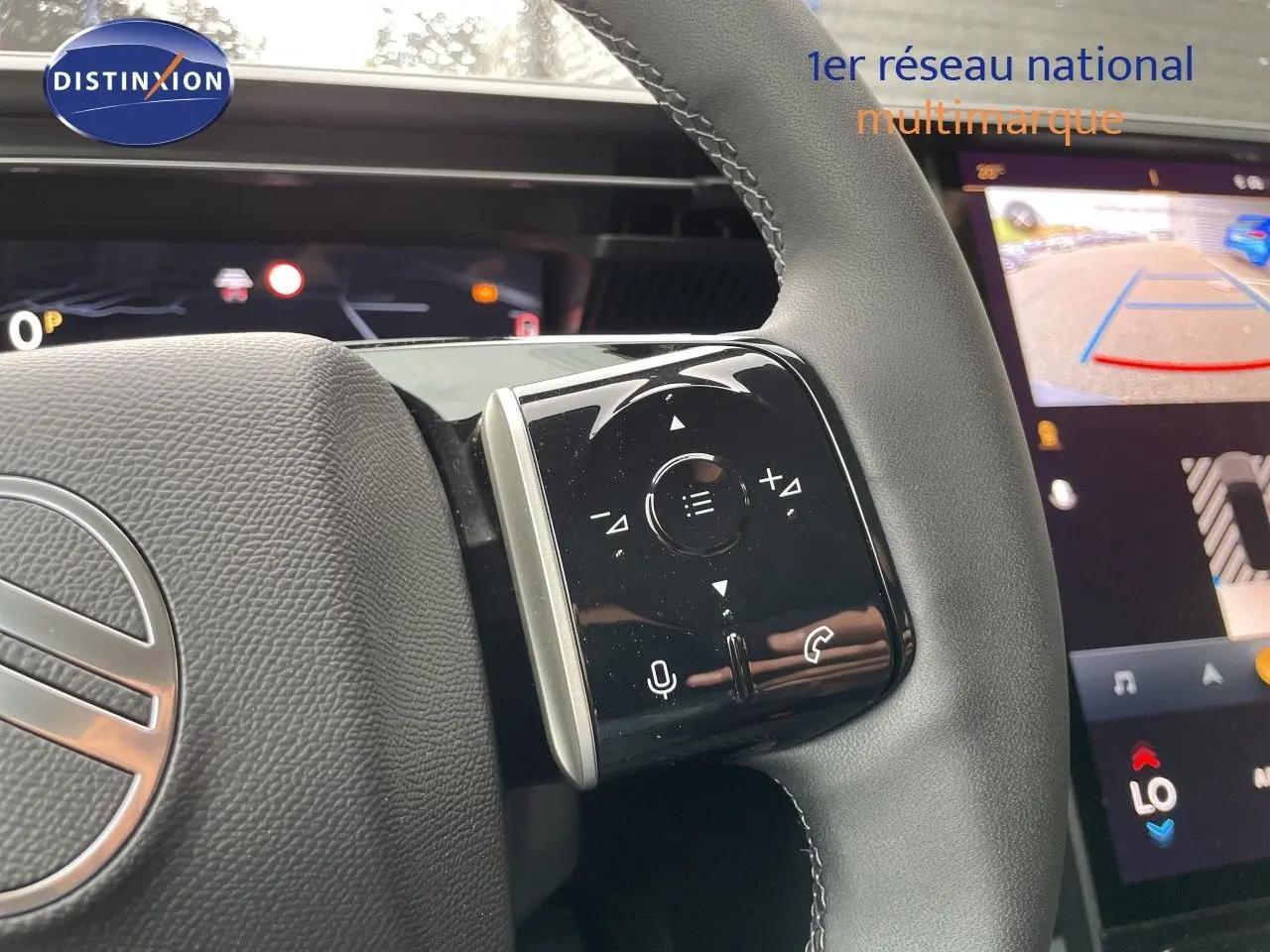 Gros plan sur la commande droite du volant noir du Citroën C5 Aircross Hybrid 2026 avec écran tactile de caméra de recul en arrière-plan.