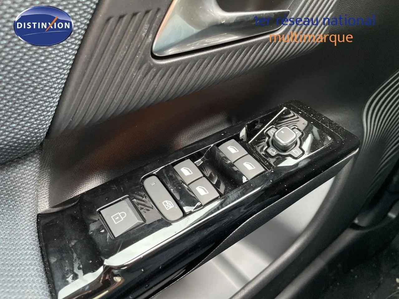 Gros plan sur les commandes de lève-vitres et rétroviseurs côté conducteur d’un Citroën C5 Aircross gris platinium 2026.