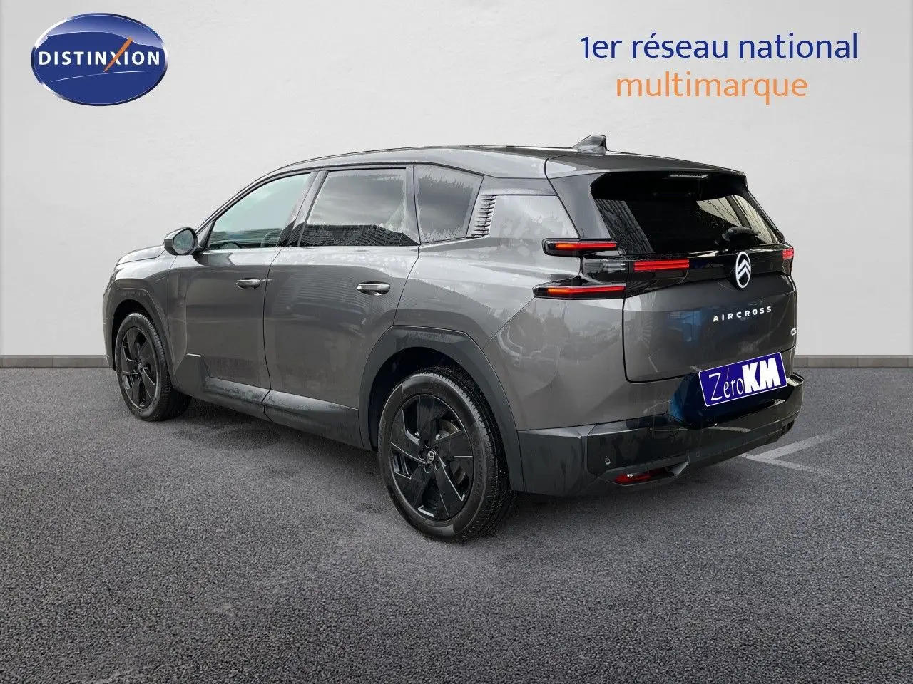 Vue 3/4 arrière droite d'un Citroën C5 Aircross Hybrid gris platinium métallisé avec jantes noires et feux arrière LED.