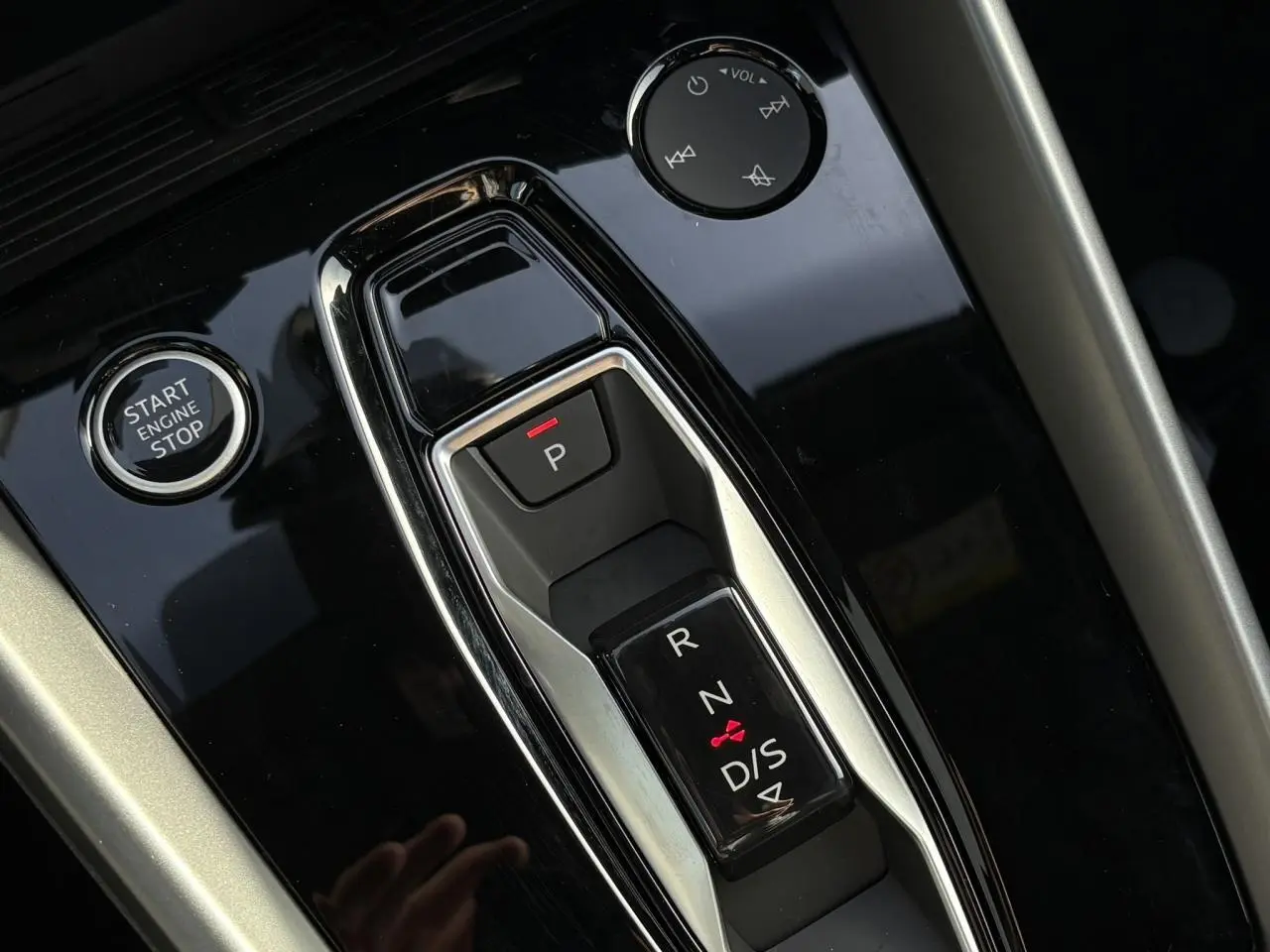 Gros plan sur la console centrale noire brillante de l'Audi A3 Berline 30 TFSI avec sélecteur de boîte auto et bouton Start/Stop.