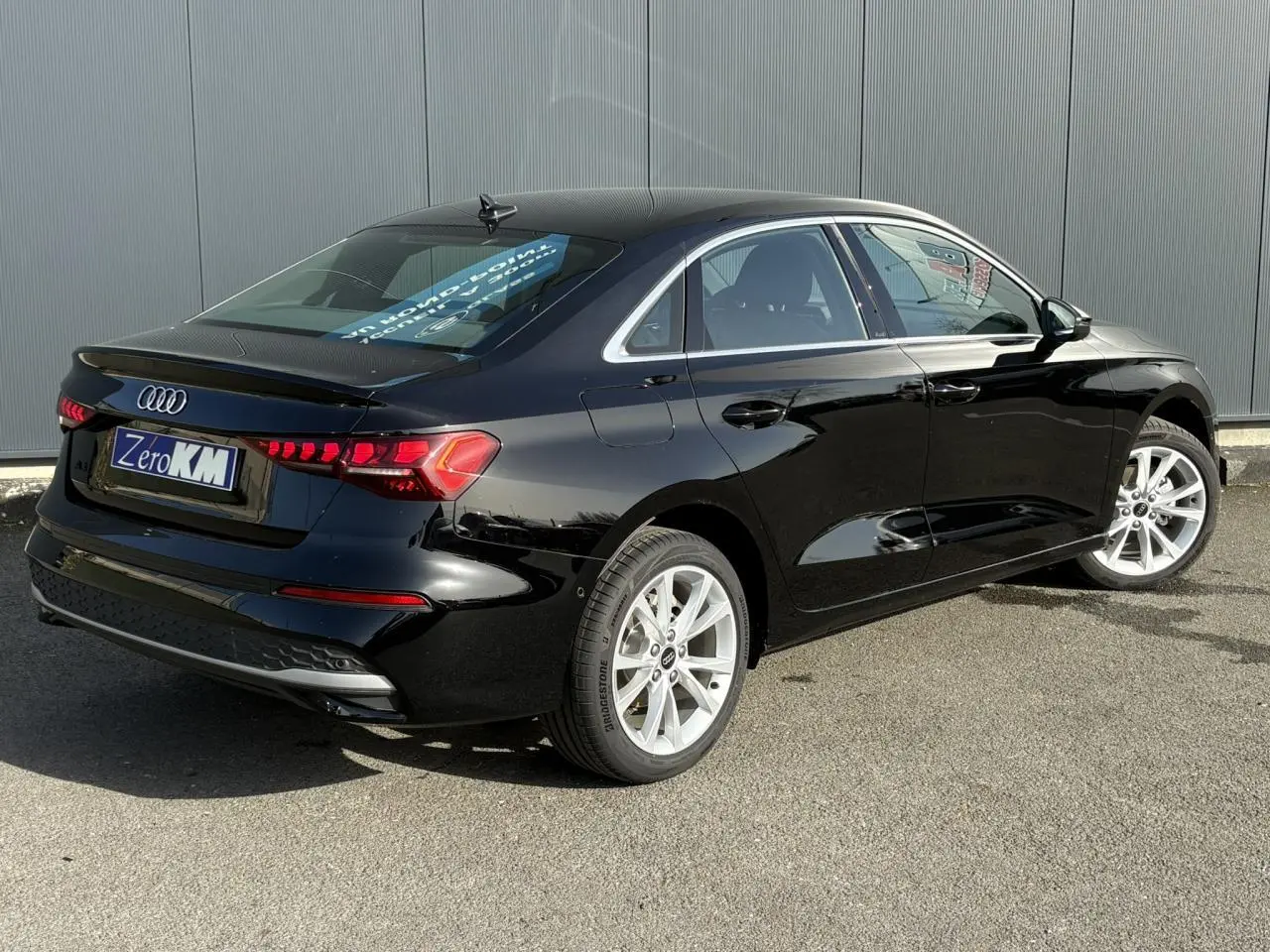 Audi A3 Berline noir Mythe vue 3/4 arrière droit, mettant en valeur ses jantes alliage 17 pouces et feux LED dynamiques.