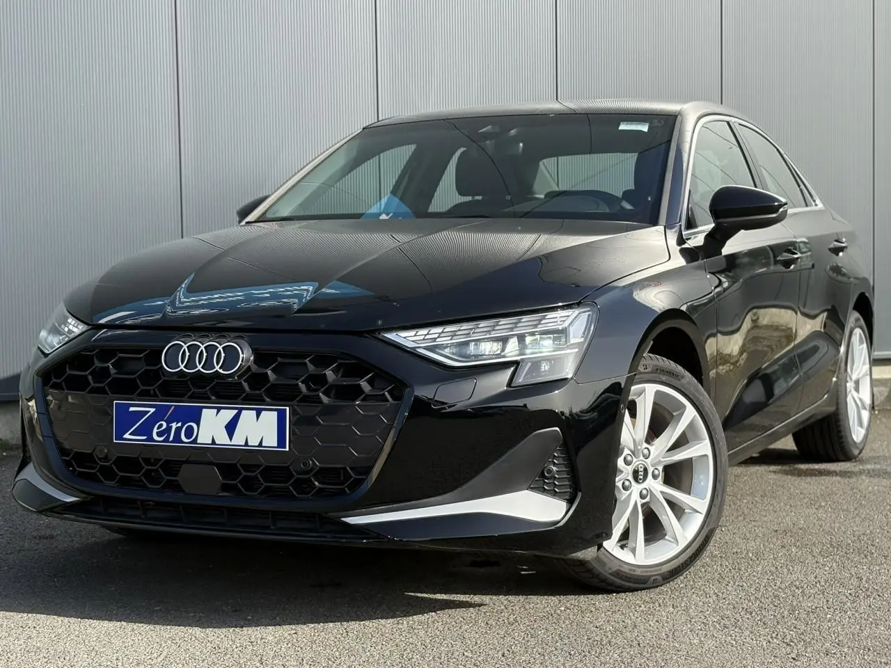 Audi A3 Berline noir Mythe vue 3/4 avant droit, mettant en valeur sa calandre hexagonale et ses phares LED distinctifs.