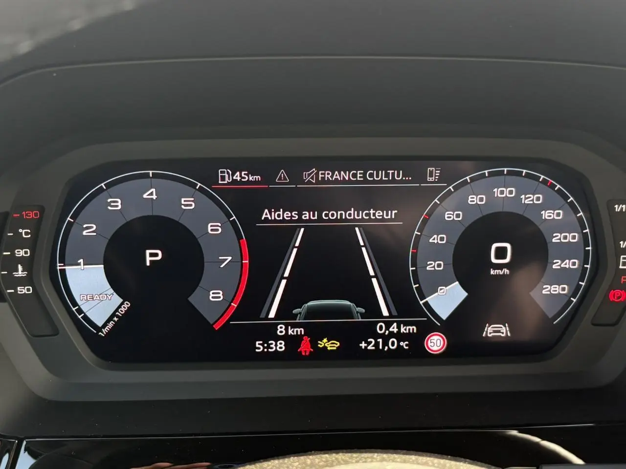 Affichage numérique du tableau de bord de l'Audi A3 Berline 2024, montrant les aides au conducteur et la vitesse à 0 km/h.