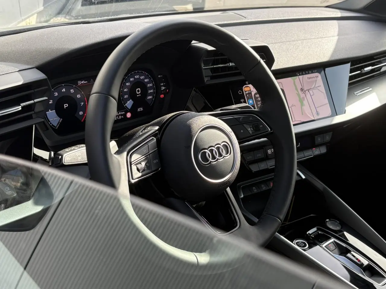 Intérieur Audi A3 Berline 30 TFSI 2024 vu côté conducteur, volant cuir multifonctions et écran tactile central.