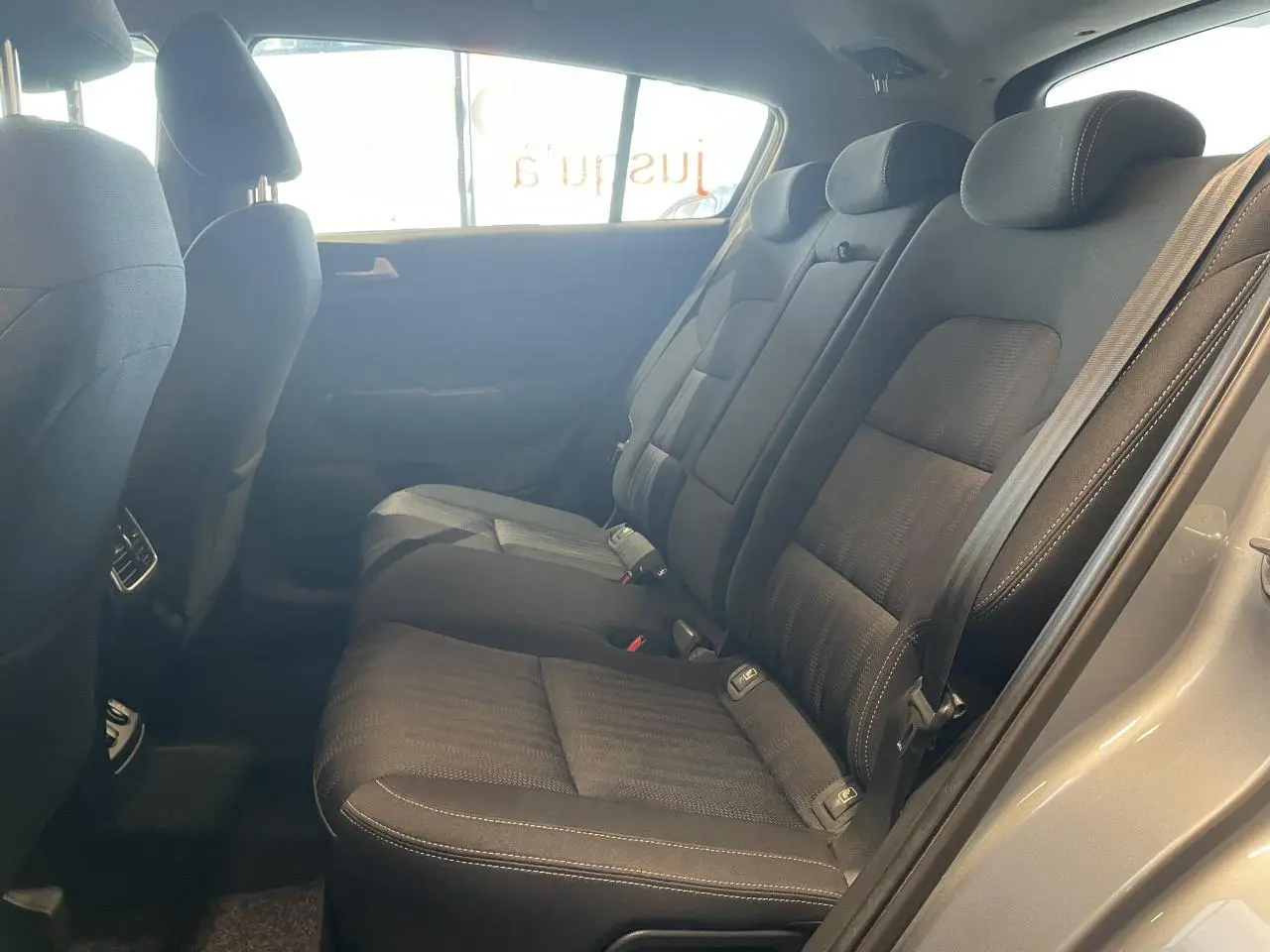 Vue intérieure côté droit des sièges arrière en tissu noir du Kia Sportage gris clair 2021.