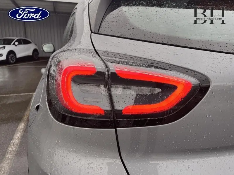 Gros plan sur le feu arrière gauche allumé d’un Ford Puma gris Solar métallisé sous la pluie.