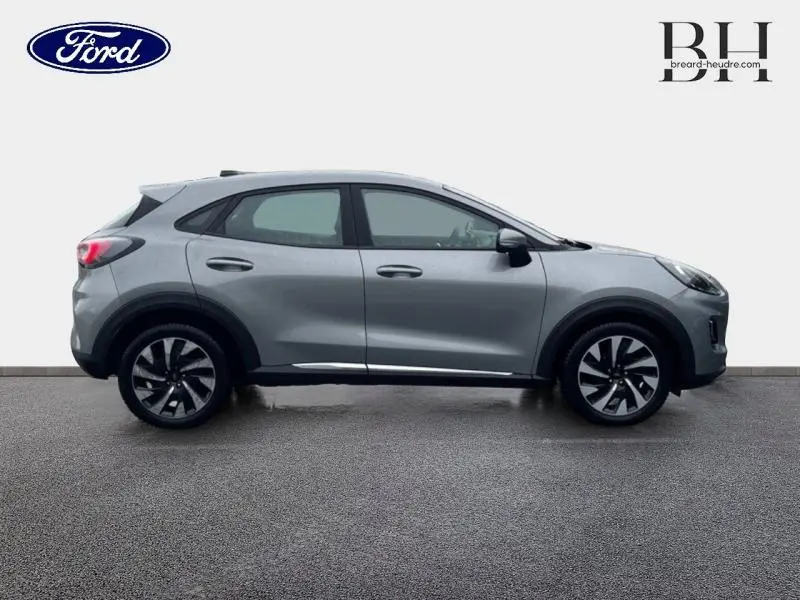 Vue de profil côté droit du Ford Puma 2023 gris Solar Métallisé avec jantes alliage distinctives et lignes dynamiques.