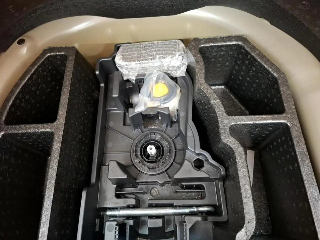 Coffre ouvert montrant le rangement pour kit de dépannage pneumatique de la Peugeot 208 gris Artense.