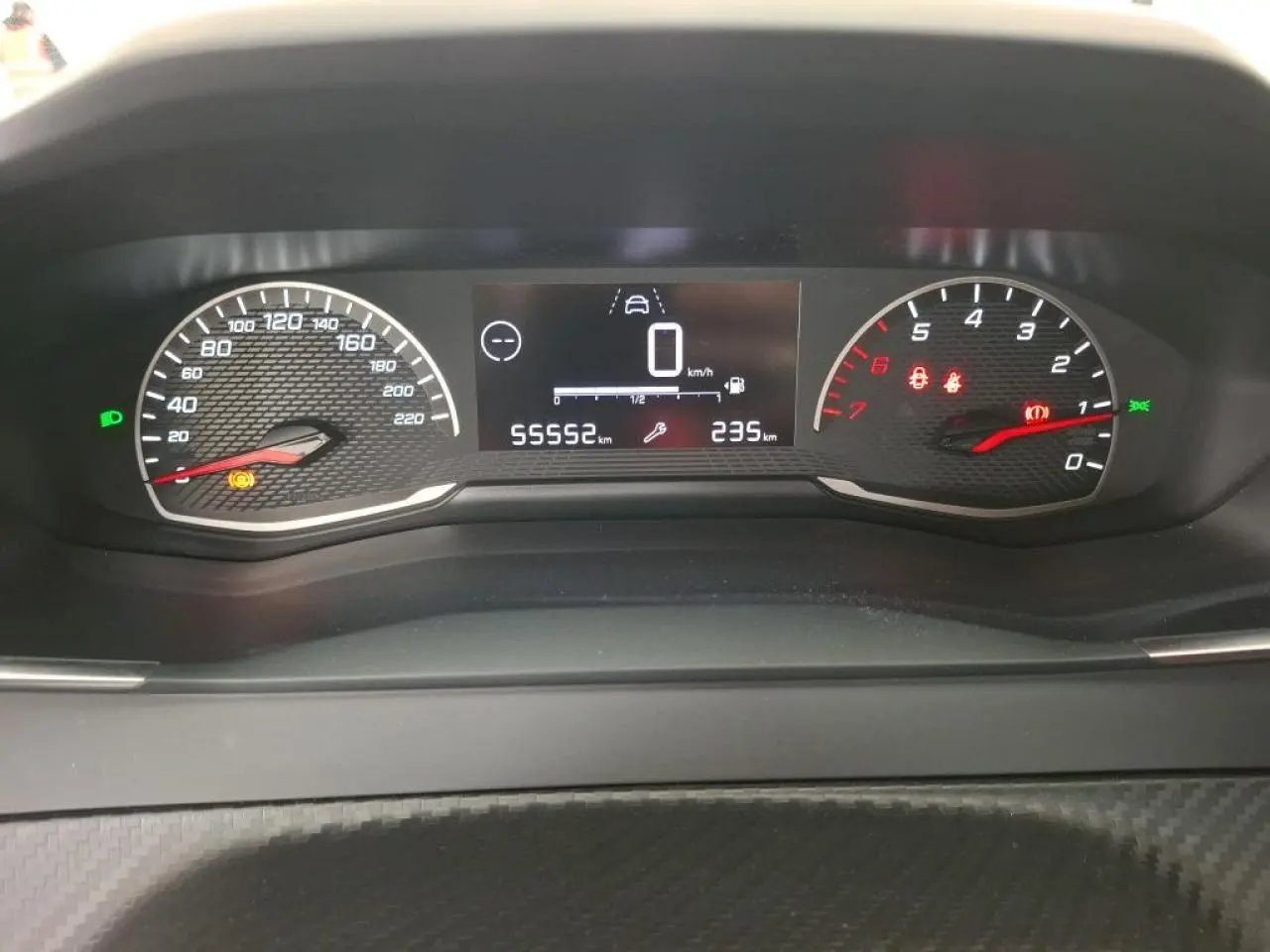 Vue rapprochée du combiné d'instruments numérique et analogique de la Peugeot 208 gris Artense, affichant 55552 km.