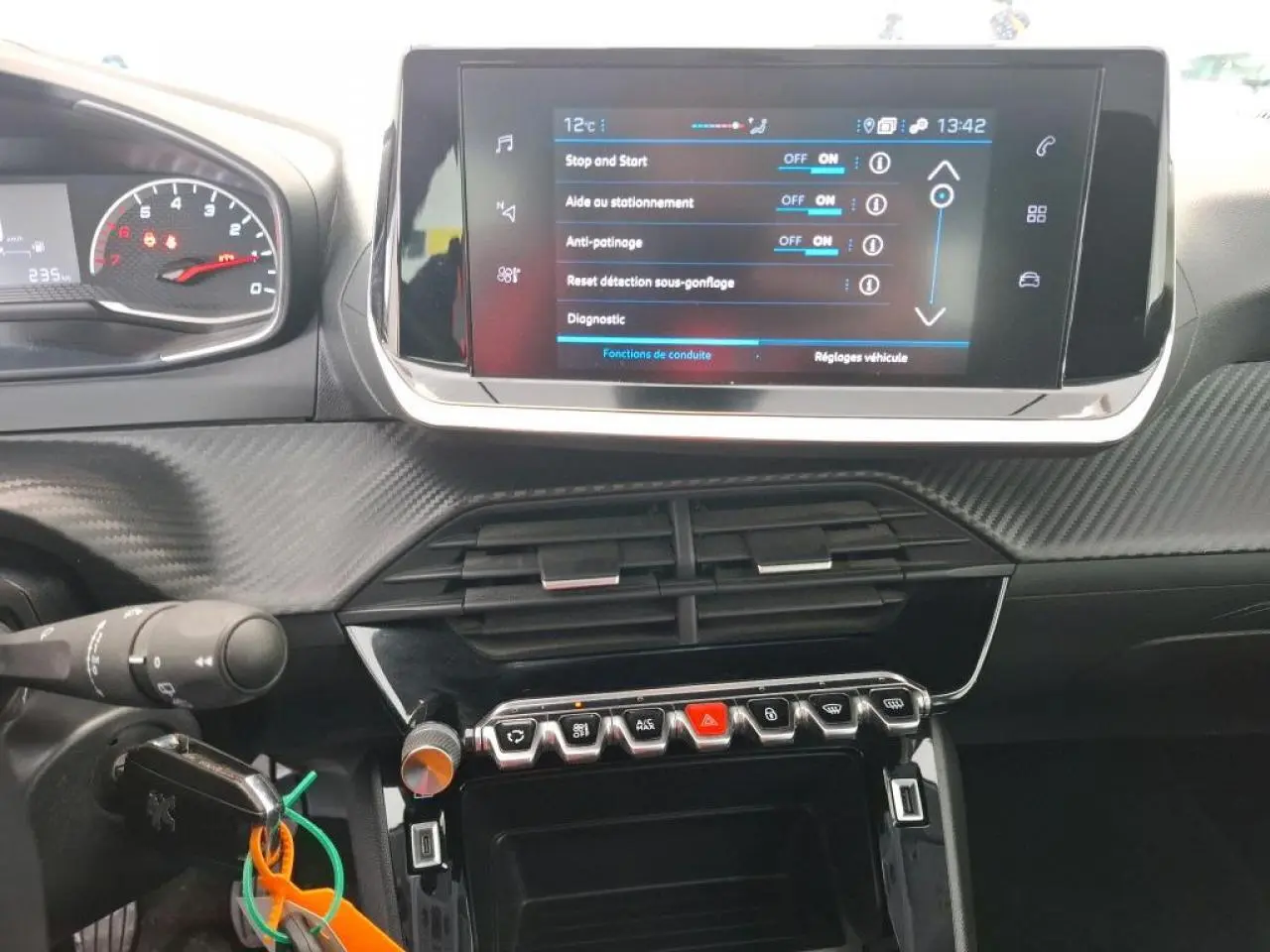 Vue rapprochée de la console centrale et du tableau de bord noir avec écran tactile et commandes sur Peugeot 208 gris Artense.