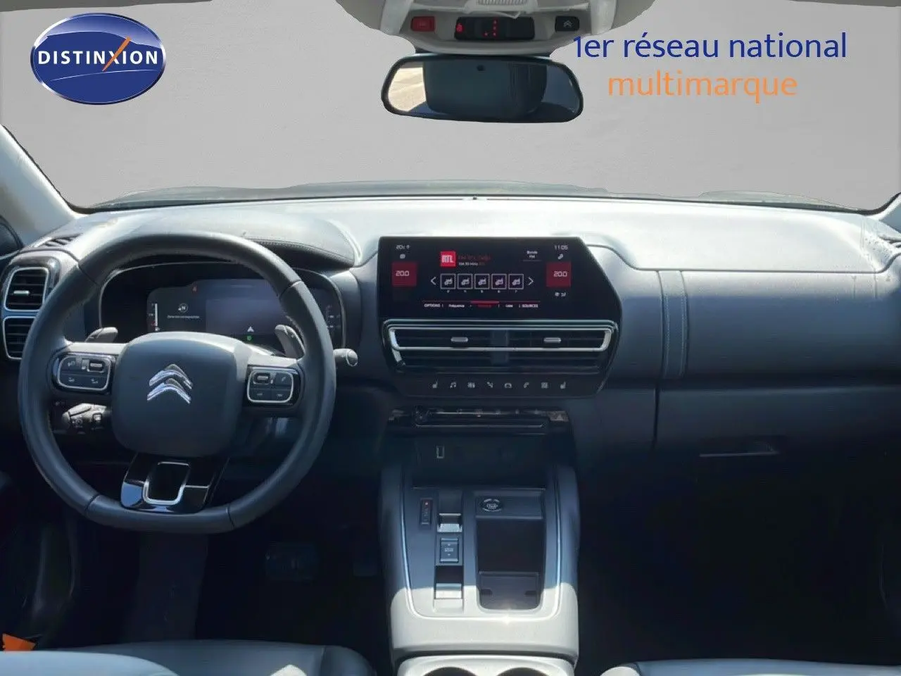 Vue intérieure du tableau de bord et volant du Citroën C5 Aircross gris platinium, avec écran tactile central et commandes au volant.
