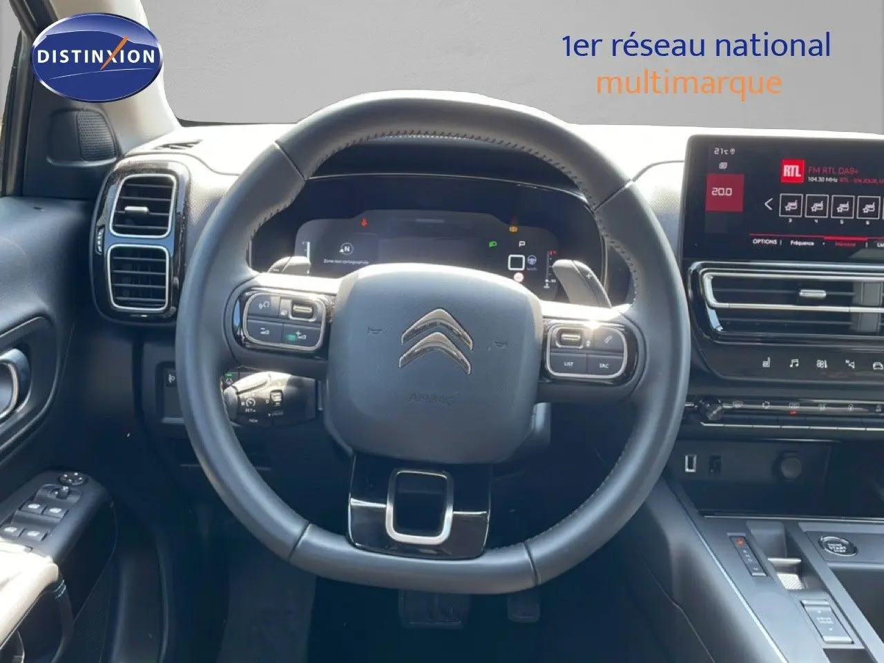 Vue intérieure centrée sur le volant cuir noir et le tableau de bord numérique du Citroën C5 Aircross gris platinium.