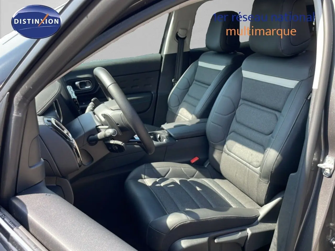 Vue intérieure côté conducteur du Citroën C5 Aircross gris platinium, sièges en tissu et cuir noir avec volant multifonction.