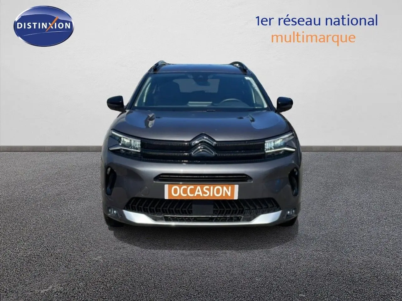 Vue avant d'un Citroën C5 Aircross gris platinium métal 2025 avec calandre noire et plaques "OCCASION" visibles.