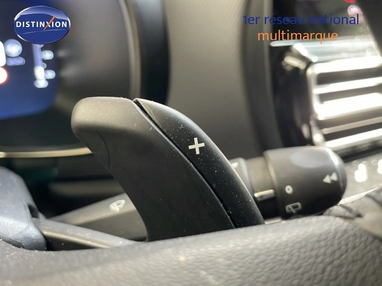 Gros plan sur la palette de changement de vitesse "+" côté droit du volant dans l'habitacle d'un Citroën C5 Aircross gris platinium.
