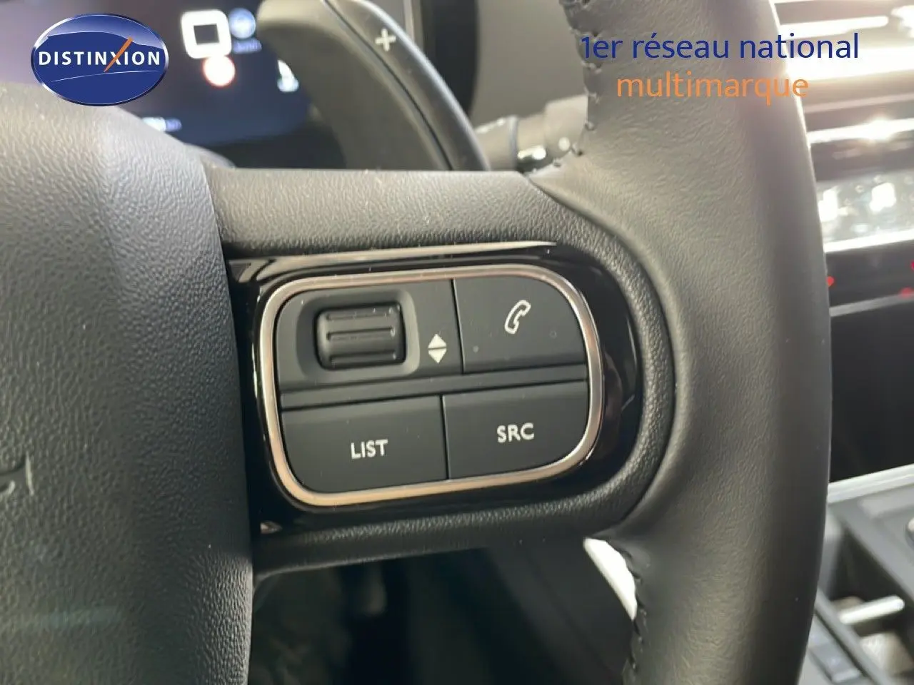 Gros plan sur les commandes gauche du volant cuir du Citroën C5 Aircross gris platinium, avec boutons de téléphonie et audio.