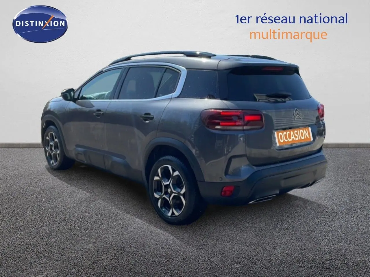 Vue 3/4 arrière droite d’un Citroën C5 Aircross gris platinium métal avec jantes bi-ton et toit panoramique.