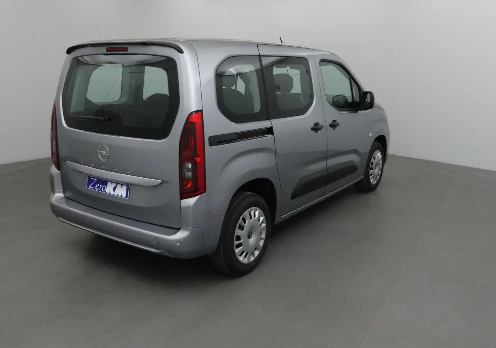 Vue 3/4 arrière droite d'un Opel Combo Life gris Artense avec becquet arrière et vitres teintées.