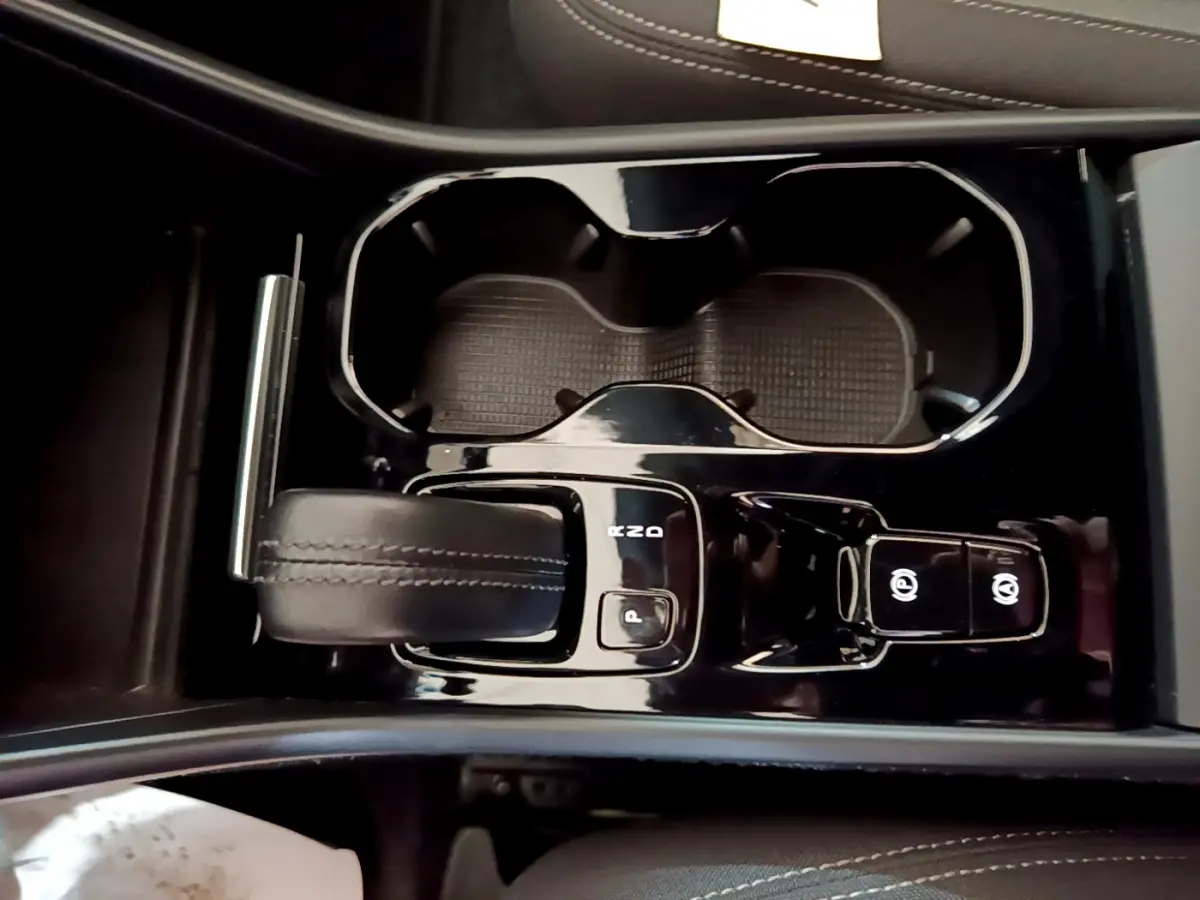 Vue rapprochée de la console centrale noire du Volvo XC40 T2 2020, avec levier de vitesses et porte-gobelets.