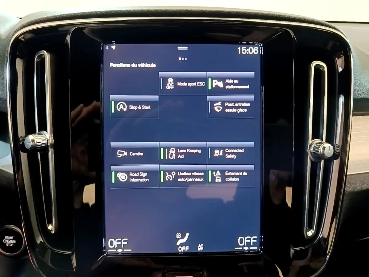 Écran tactile central affichant les fonctions d’aide à la conduite du Volvo XC40 T2 gris clair, vue de face rapprochée.