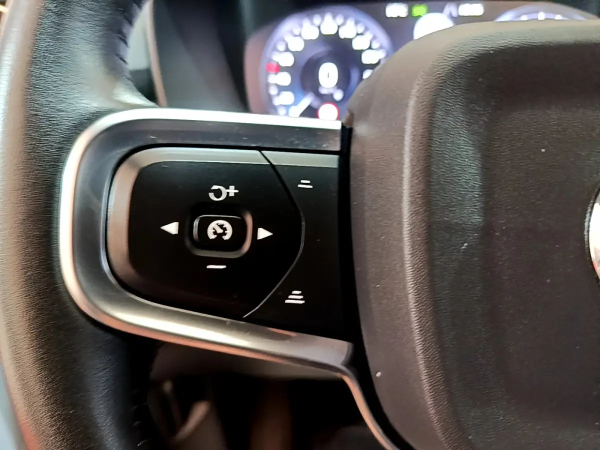 Gros plan sur les commandes de régulateur de vitesse au volant cuir noir du Volvo XC40 T2 Momentum 2020.