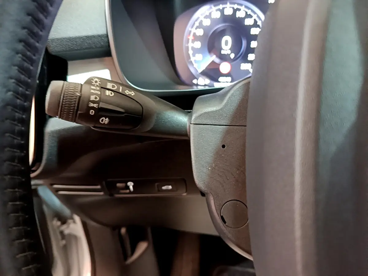 Gros plan sur la manette des feux et le tableau de bord numérique du Volvo XC40 T2 Momentum gris clair de 2020.