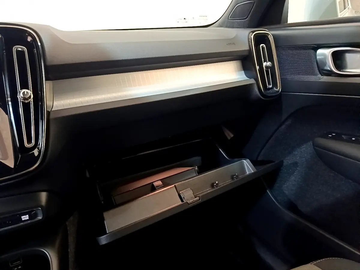 Intérieur du Volvo XC40 T2 2020, vue côté passager sur la boîte à gants ouverte et la planche de bord grise.