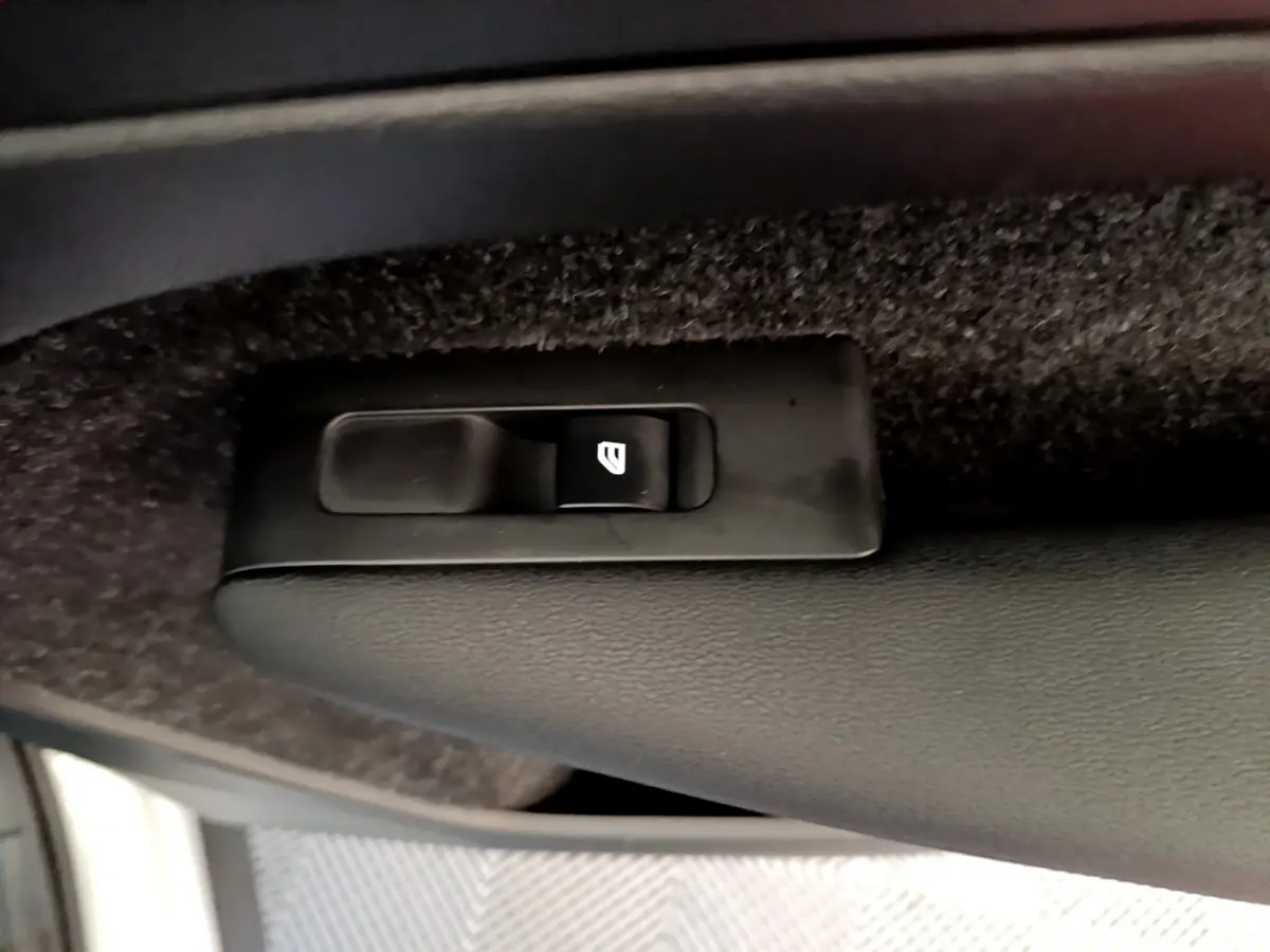 Gros plan sur l'interrupteur de lève-vitre côté conducteur du Volvo XC40 T2 gris clair de 2020.