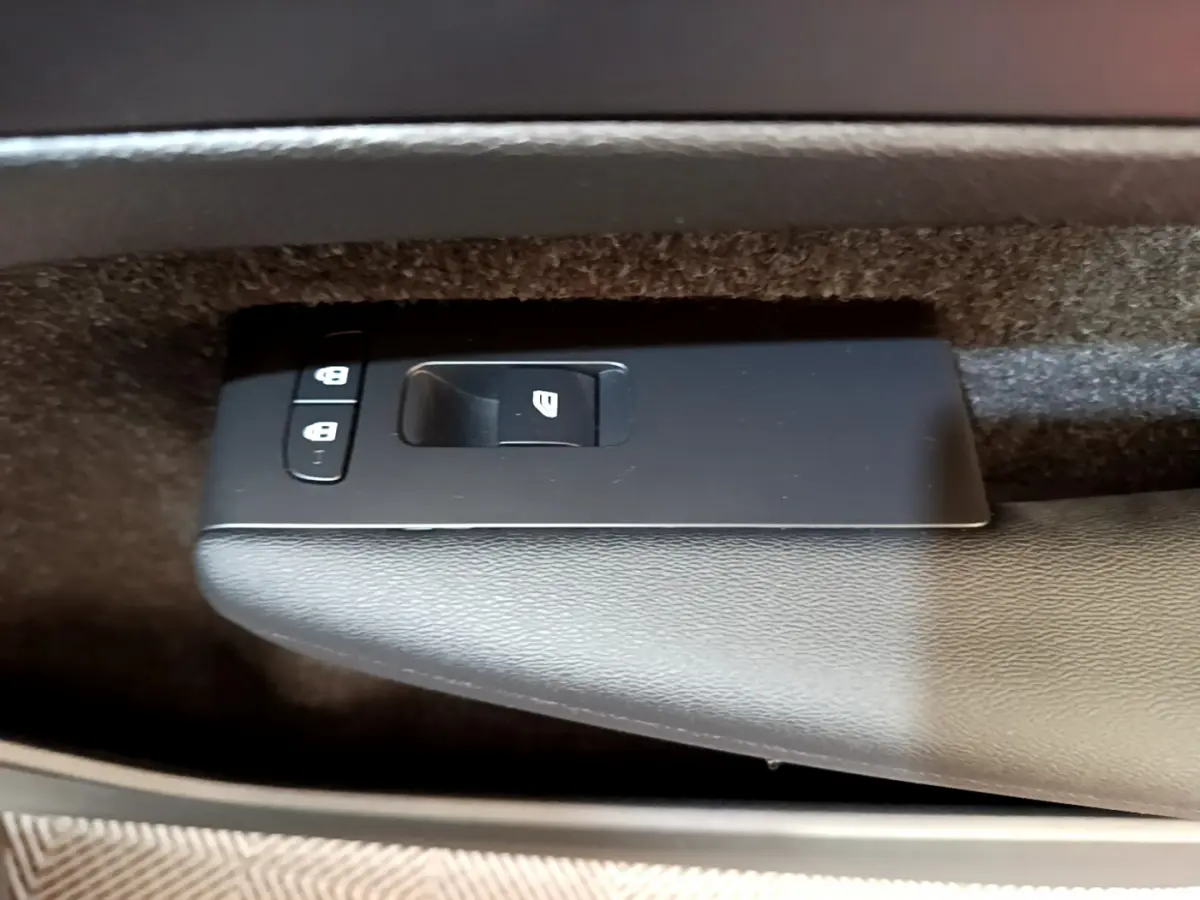 Gros plan sur les commandes de verrouillage et lève-vitre côté conducteur du Volvo XC40 T2 gris clair de 2020.