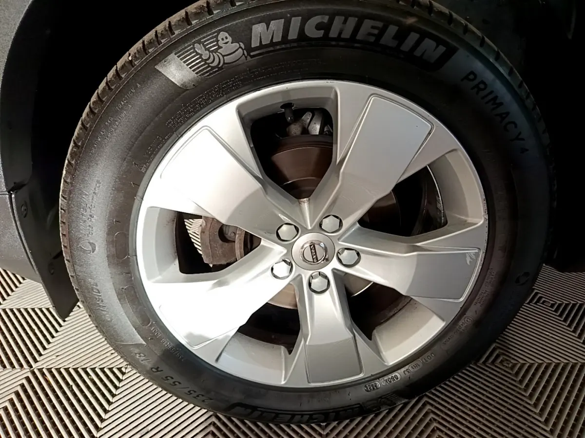 Vue rapprochée sur la roue arrière gauche d'un Volvo XC40 gris clair avec pneu Michelin visible.