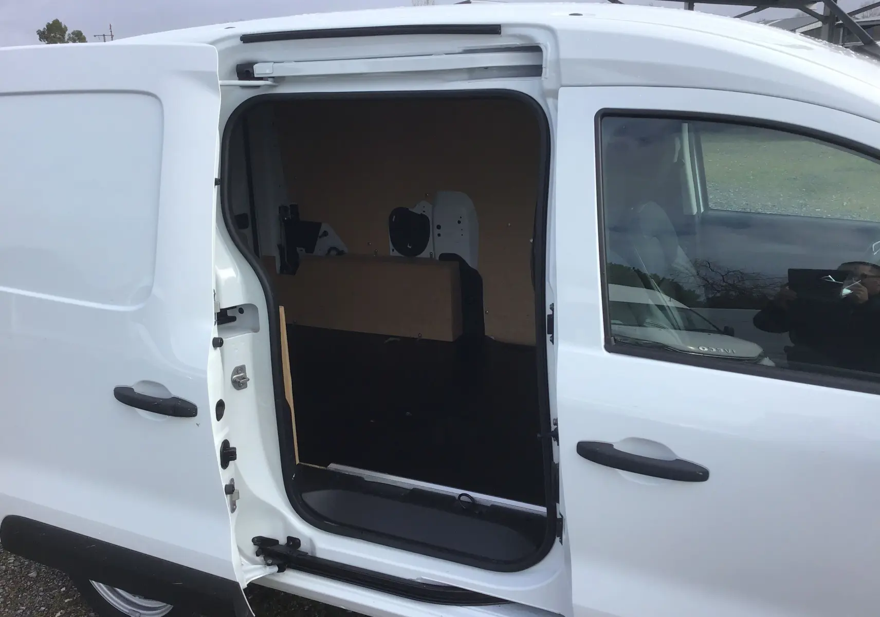 Vue latérale droite d’un Renault Express Van blanc 2023 avec porte coulissante ouverte dévoilant l’espace de chargement vide.