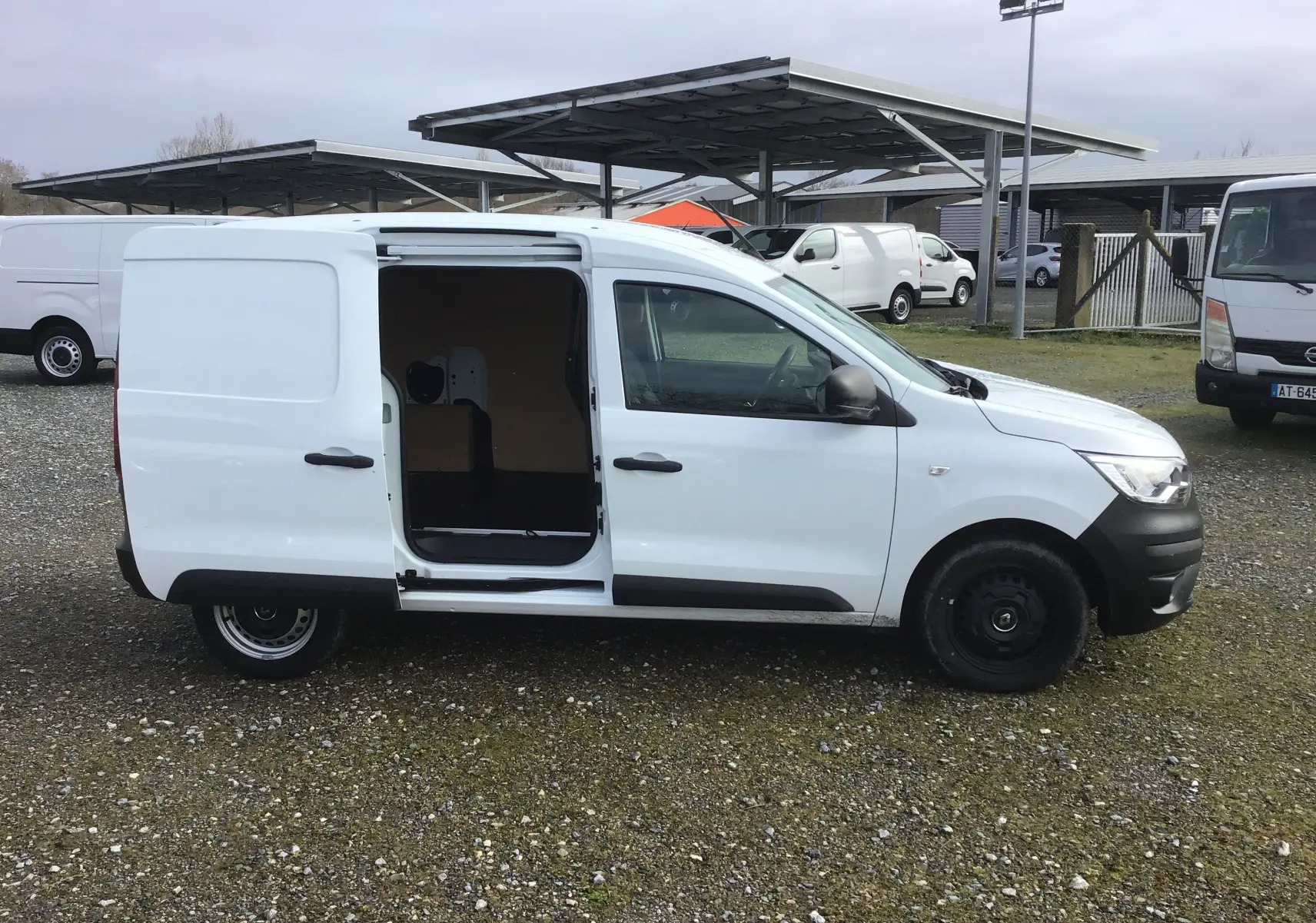 Renault Express Van blanc vu de profil droit avec porte latérale coulissante ouverte, intérieur de chargement visible.