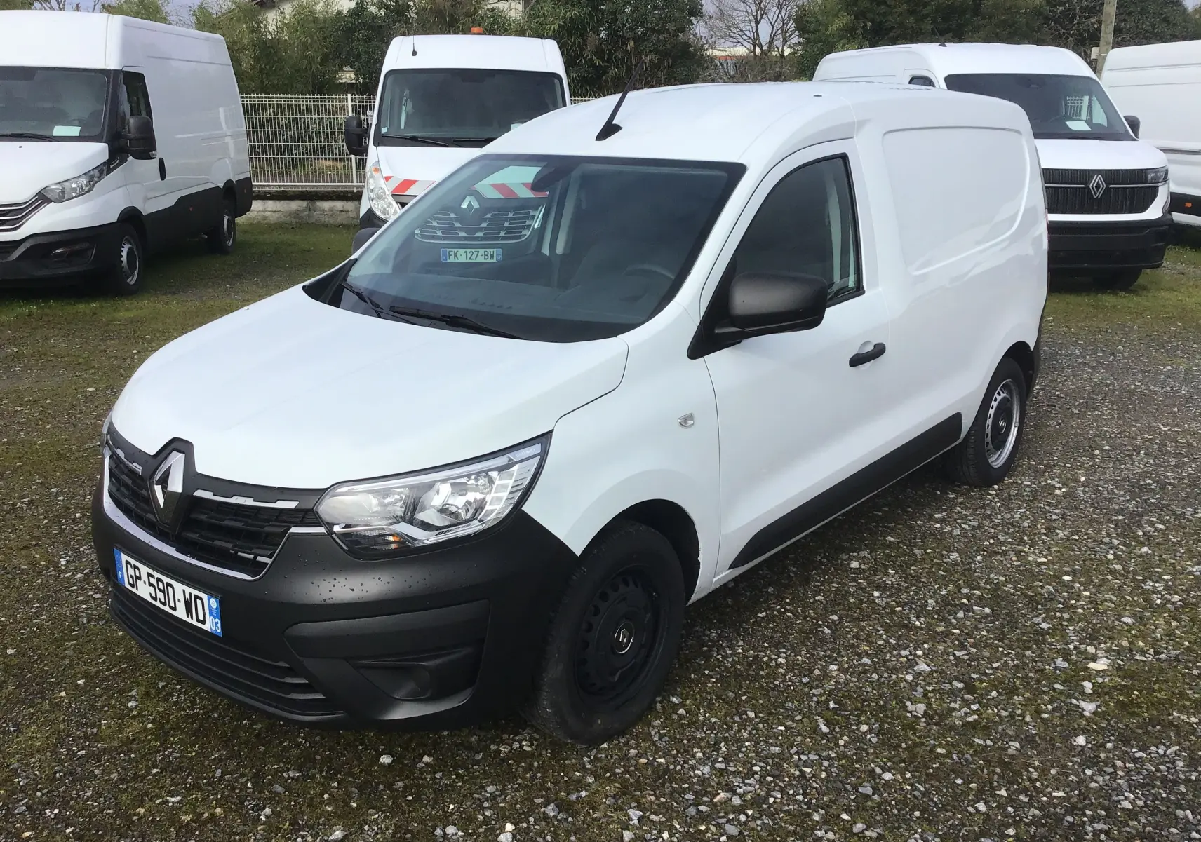 Vue 3/4 avant droite d’un Renault Express Van blanc 2023 avec pare-chocs noirs et jantes tôles noires sur parking.
