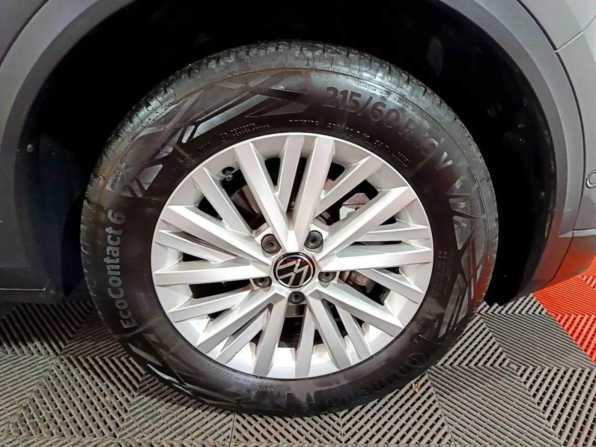 Gros plan sur la roue avant droite du Volkswagen T-Roc gris foncé, jante alliage à rayons multiples.