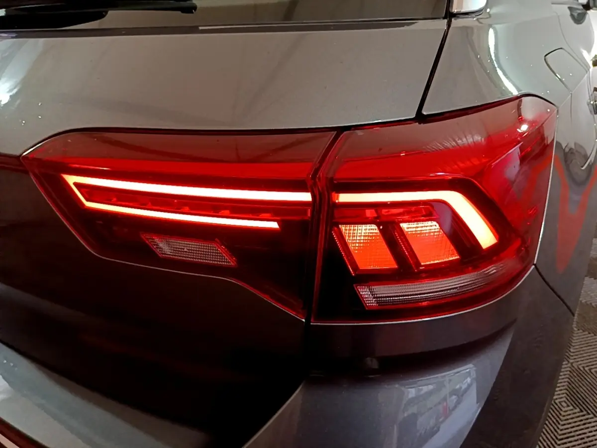 Gros plan sur le feu arrière droit rouge allumé du Volkswagen T-Roc gris foncé, version 2022.