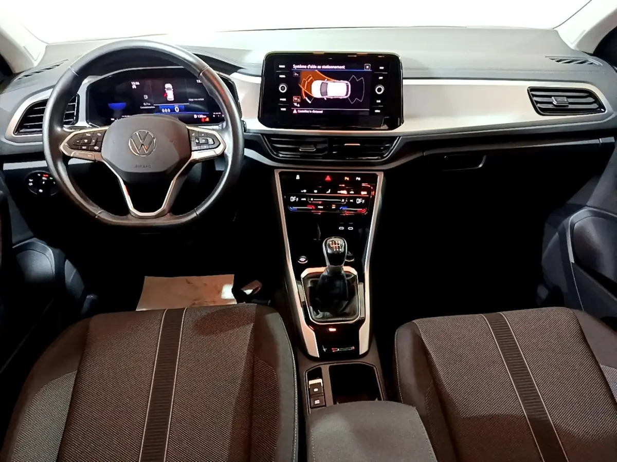 Vue intérieure avant du Volkswagen T-Roc 1.0 TSI 110 LIFE BUSINESS 2022, tableau de bord et volant cuir noir.