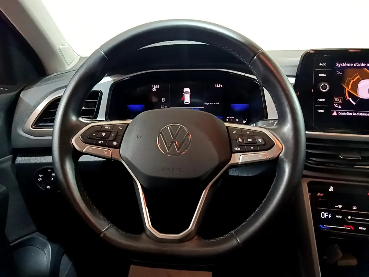 Vue intérieure centrée sur le volant cuir multifonctions d’un Volkswagen T-Roc 2022 avec tableau de bord digital.