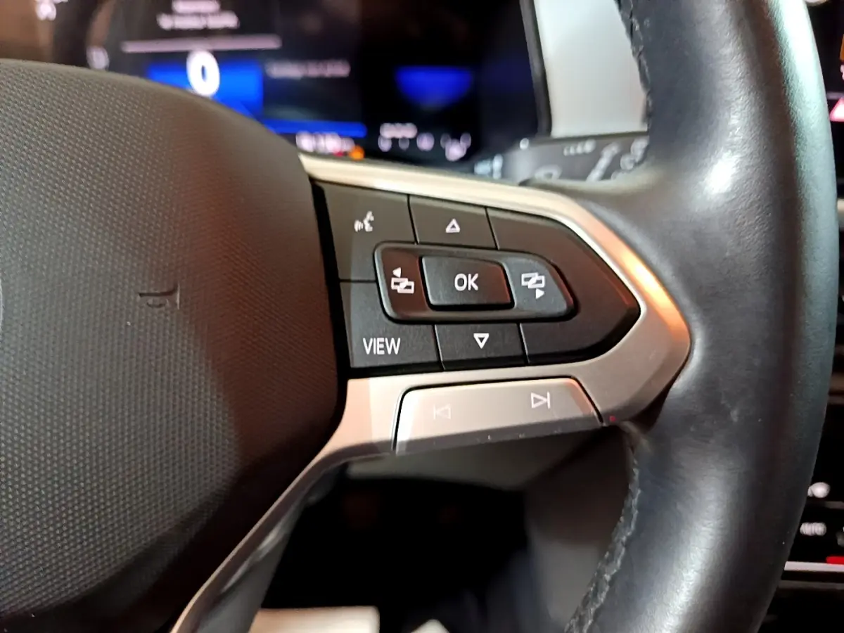 Gros plan sur les commandes multifonctions du volant cuir noir du Volkswagen T-Roc gris foncé, version 2022.