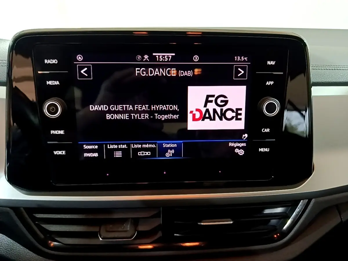 Écran tactile central affichant la radio FG.DANCE dans l'habitacle du Volkswagen T-Roc gris foncé.