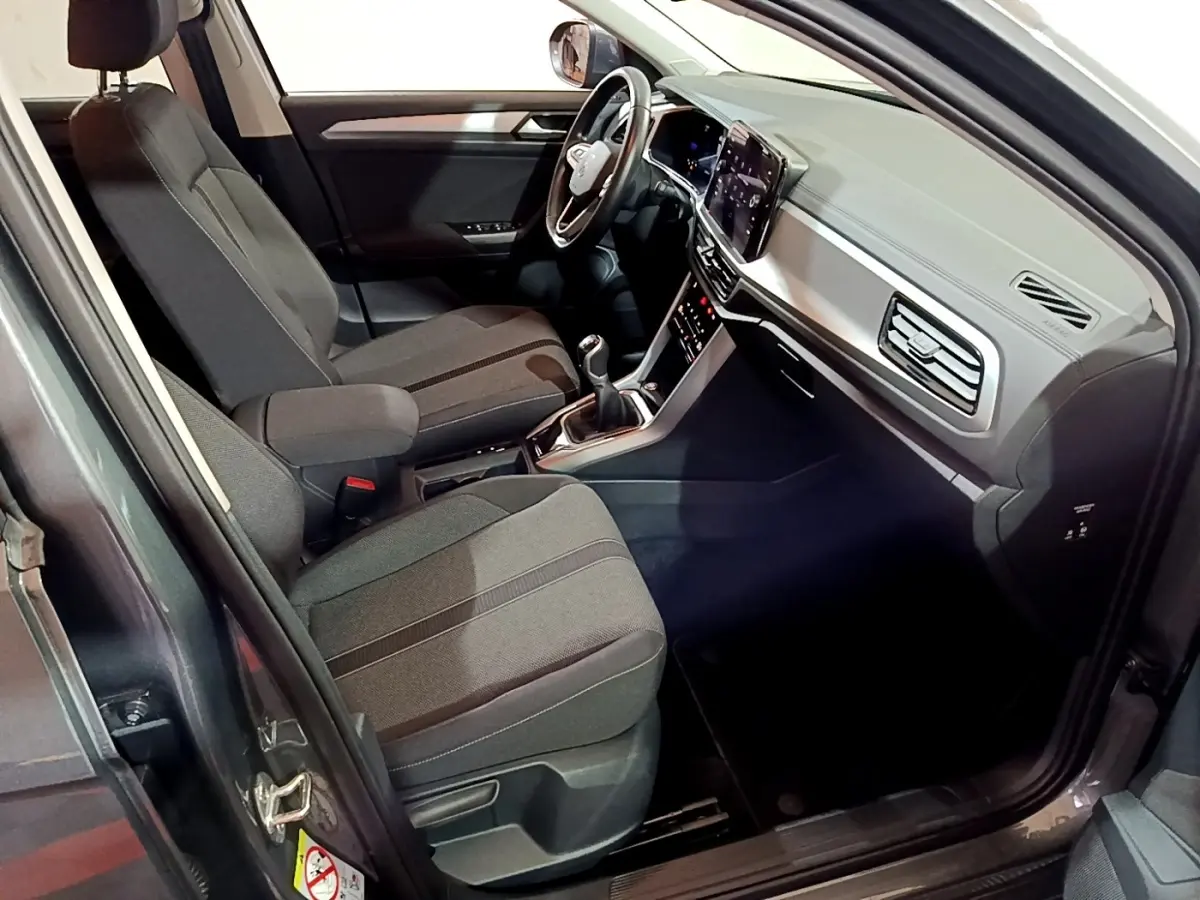 Intérieur avant droit du Volkswagen T-Roc gris foncé 2022, avec sièges tissu et tableau de bord numérique.