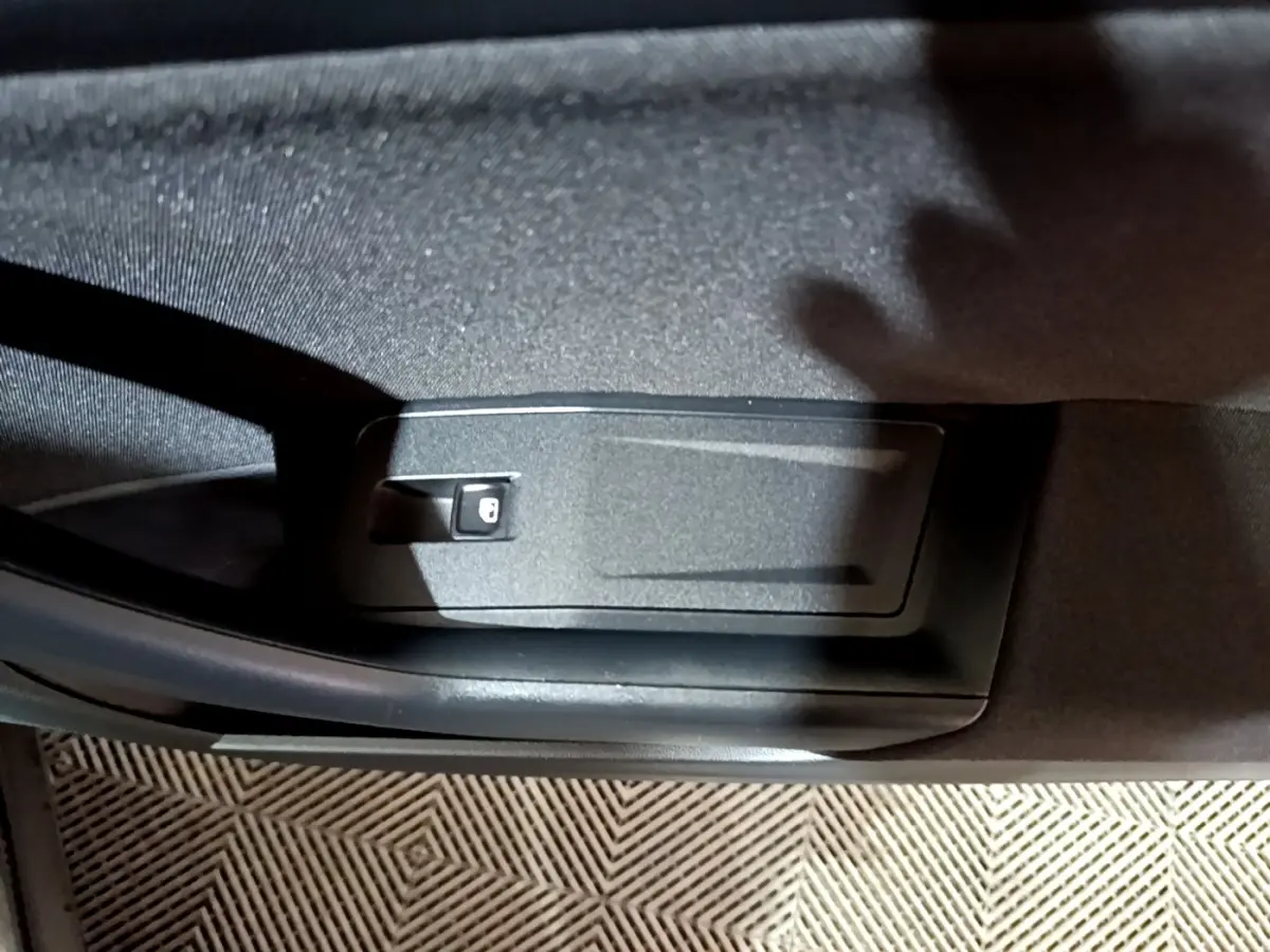 Détail de la commande de verrouillage sur la porte intérieure côté conducteur d’un Volkswagen T-Roc gris foncé 2022.